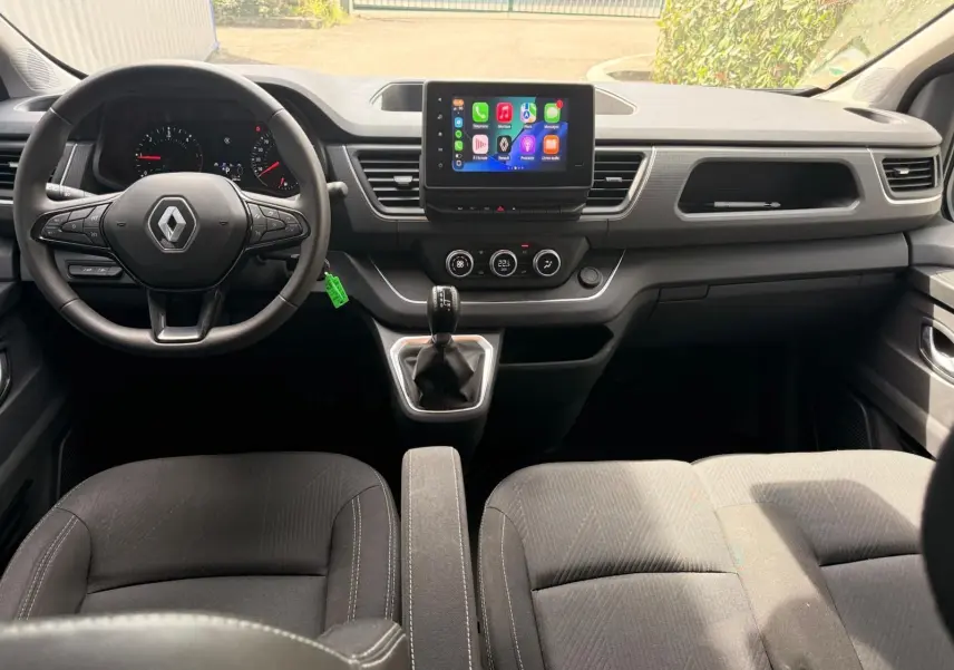 Vue intérieure frontale du poste de conduite du Renault Trafic Cabine Approfondie 2024 avec tableau de bord moderne et écran tactile central.