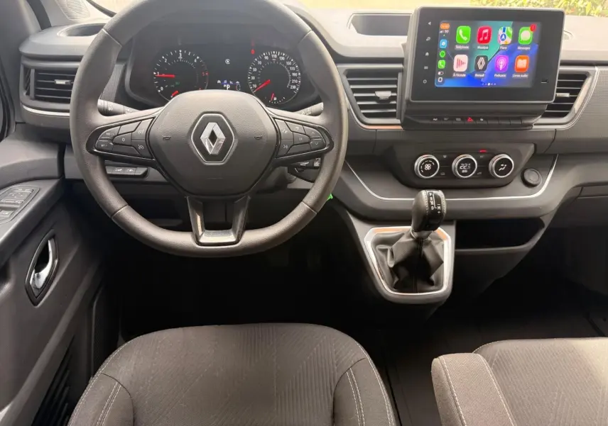 Vue intérieure frontale du tableau de bord gris du Renault Trafic Cabine Approfondie avec volant multifonction et écran tactile central.