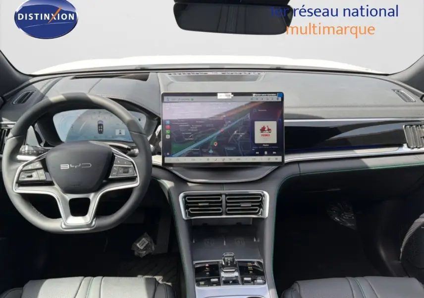 Vue intérieure avant du tableau de bord du BYD SEAL U blanc métal, avec grand écran tactile central et volant multifonction.