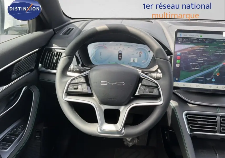 Vue intérieure centrée sur le volant BYD du SEAL U blanc métal, avec tableau de bord numérique et écran tactile.