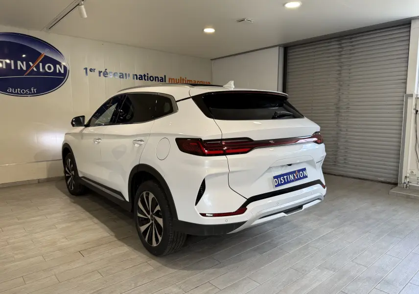Vue 3/4 arrière droite du SUV BYD SEAL U blanc métal, avec feux arrière étirés et jantes bi-ton en showroom.