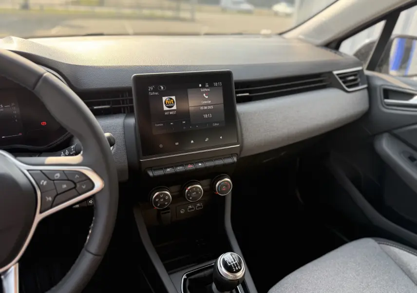 Vue intérieure de la Renault Clio 1.5 DCI 2025 montrant le tableau de bord, l'écran tactile et le levier de vitesses manuel.