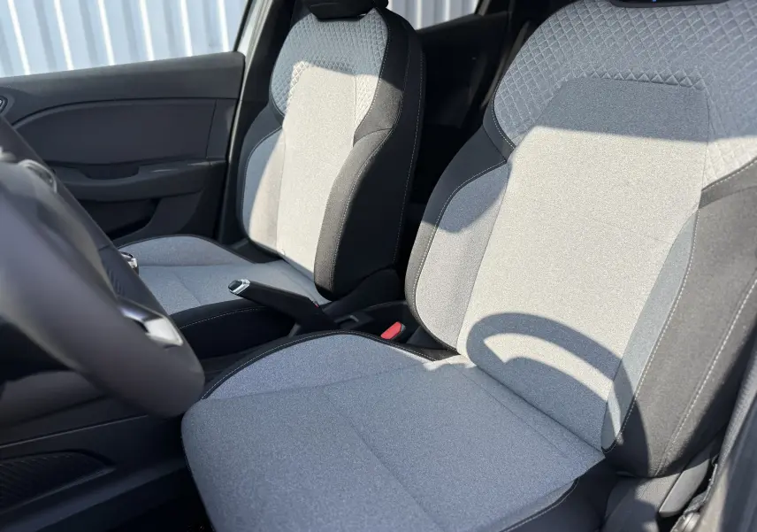 Vue rapprochée des sièges avant en tissu gris clair et noir de la Renault Clio 1.5 DCI 100CH Evolution Cam 2025.
