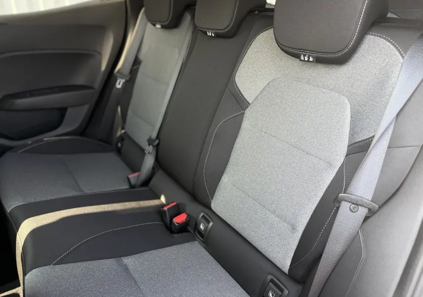 Vue intérieure sur la banquette arrière en tissu bicolore gris clair et foncé de la Renault Clio 2025.