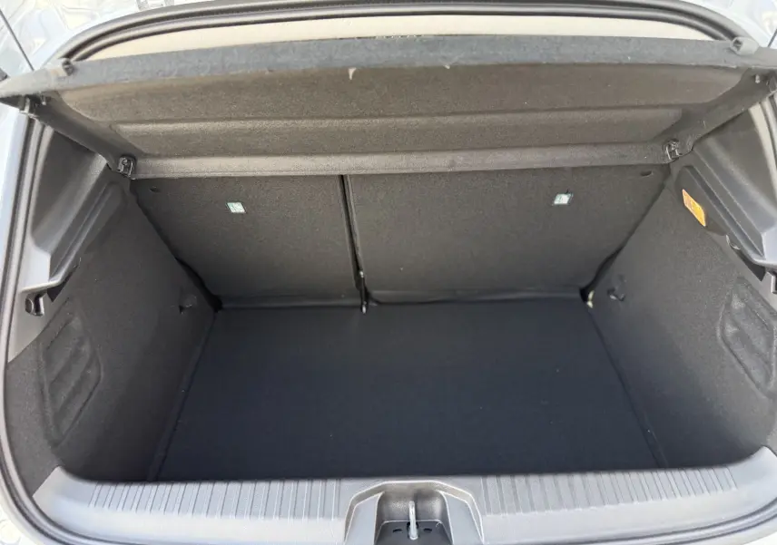 Coffre ouvert d'une Renault Clio 1.5 dCi gris Rafale métal, montrant un espace de rangement propre et spacieux.