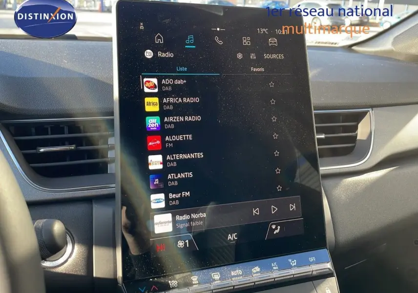 Écran tactile central allumé dans l'habitacle du Renault Captur E-Tech gris Rafale avec toit noir, vue de face.