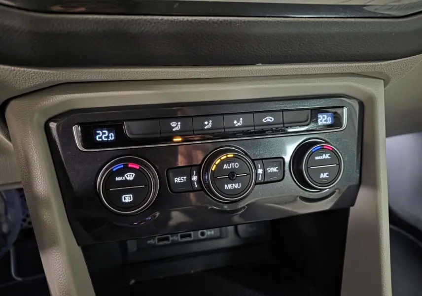 Détail de la console centrale du Volkswagen Tiguan 2018 gris, montrant les commandes de climatisation automatique tri-zone.