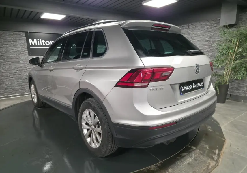Volkswagen Tiguan gris métallisé vu en 3/4 arrière droit, avec feux arrière LED et jantes alliage 17 pouces.