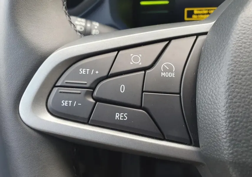 Gros plan sur les commandes de régulateur de vitesse au volant du Dacia Duster 2026, finition gris schiste.