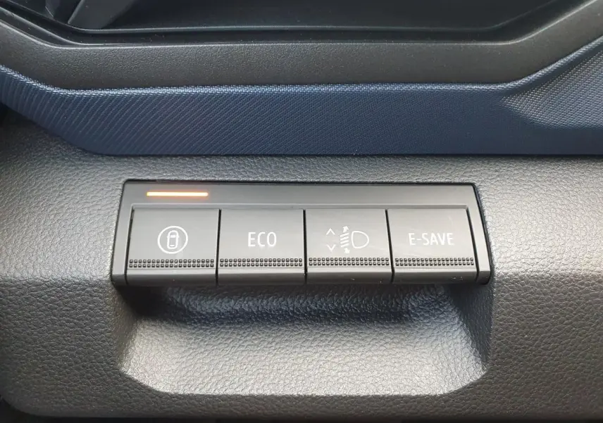 Gros plan sur les boutons de commande du tableau de bord du Dacia Duster 1.6 Hybrid 140, finition Journey+ Pack City.