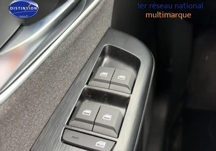 Gros plan sur les commandes des vitres électriques côté gauche d’un MG ZS blanc hybride 2026.