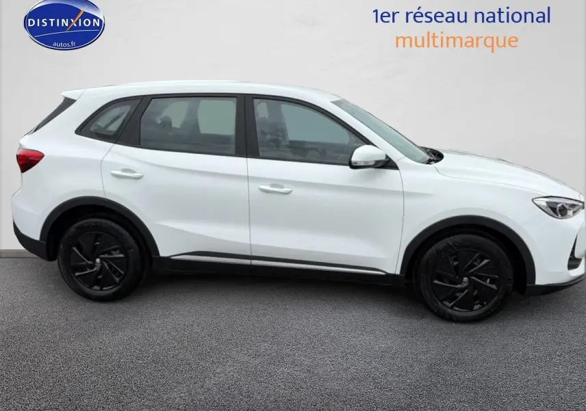 Vue de profil côté gauche d'un MG ZS Hybrid blanc avec jantes noires et lignes épurées sur fond neutre.