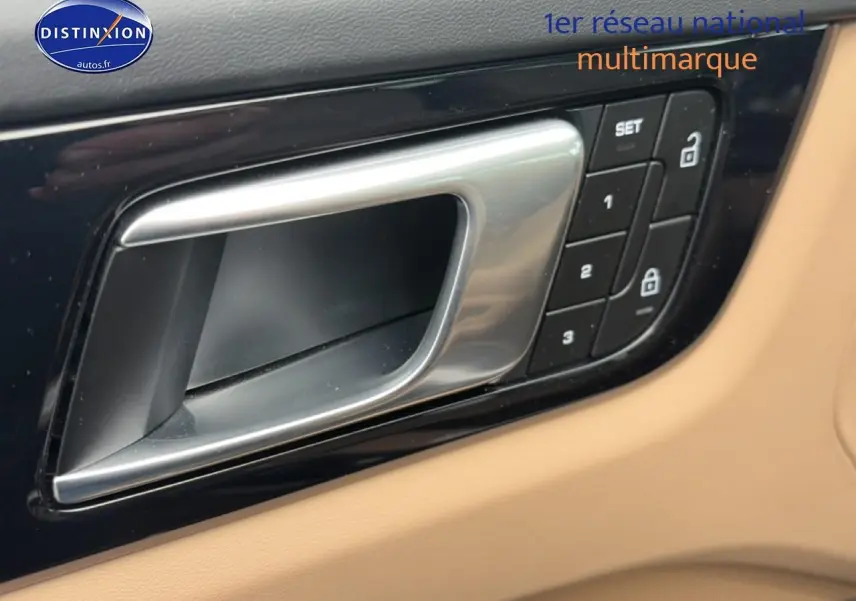 Poignée de porte intérieure argentée sur panneau beige avec commandes de verrouillage et mémoire siège, Porsche Cayenne 2023.
