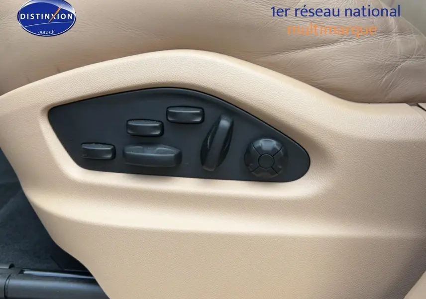 Commandes électriques de réglage du siège beige côté conducteur dans un Porsche Cayenne bleu 2023.