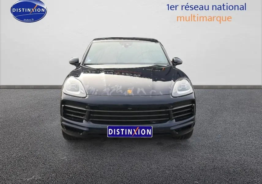 Vue frontale d'un Porsche Cayenne bleu foncé avec calandre large et phares LED distinctifs.