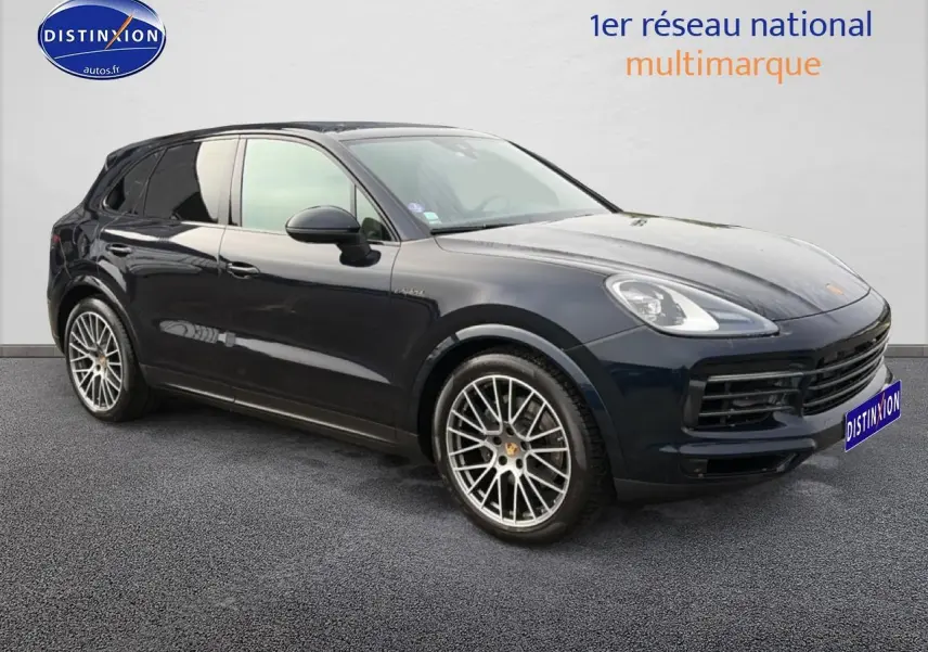 Vue 3/4 avant d’un Porsche Cayenne bleu foncé avec jantes alliage et vitres teintées.