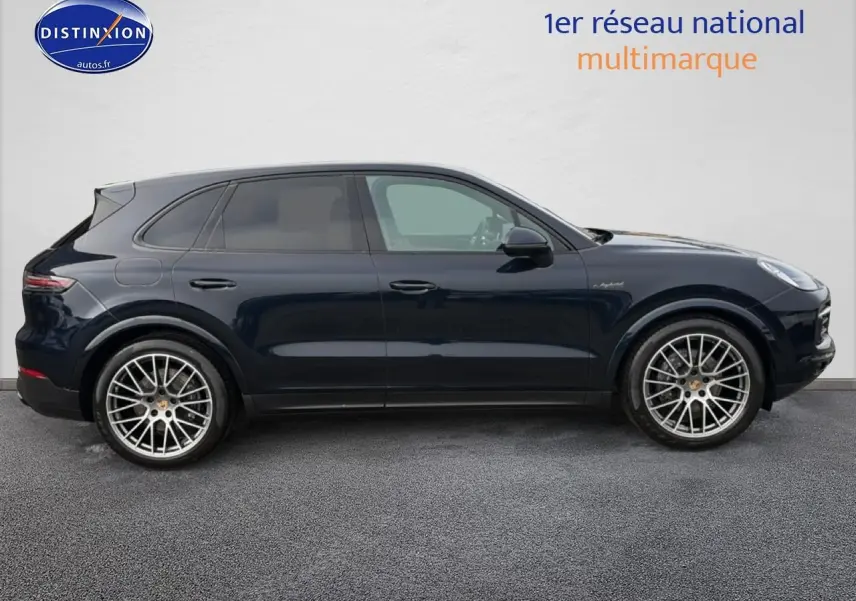 Profil droit d’un Porsche Cayenne 2023 bleu foncé avec jantes alliage et vitres teintées.