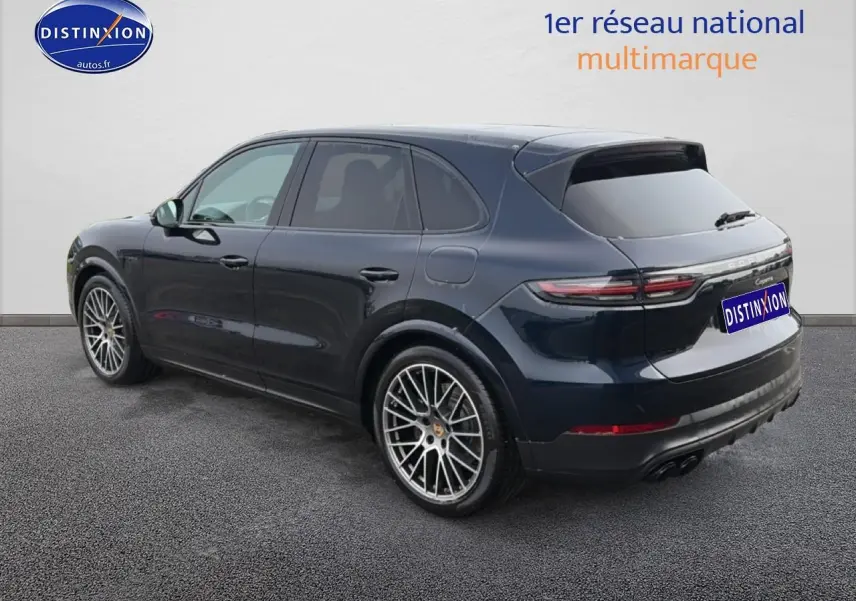 Vue 3/4 arrière droite d'un Porsche Cayenne 2023 bleu avec jantes alliage et vitres teintées.