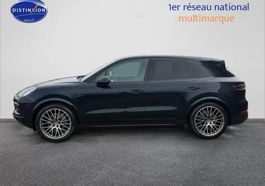 Vue de profil côté gauche d'un Porsche Cayenne 2023 bleu avec jantes alliage multibranches et vitres teintées.