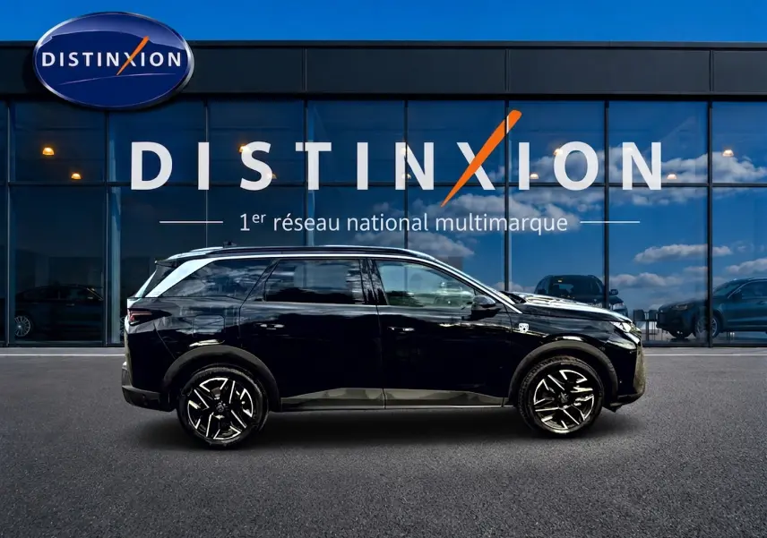 Profil côté droit d'un Peugeot 5008 Hybrid 145 GT noir, avec jantes alu et vitres arrière surteintées, devant une vitrine.