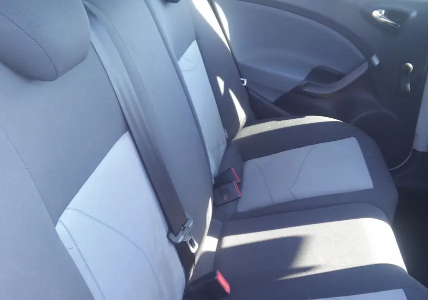 Vue intérieure montrant les sièges arrière en tissu gris et noir de la SEAT Ibiza Business 2015, avec ceinture de sécurité.