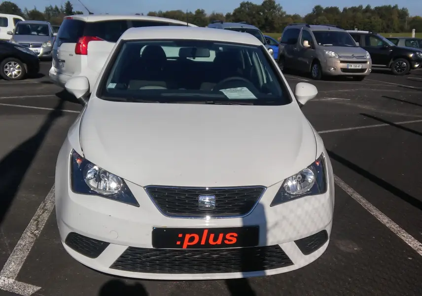 Vue avant d'une SEAT Ibiza Business blanche garée, avec calandre noire et plaque :plus visible.