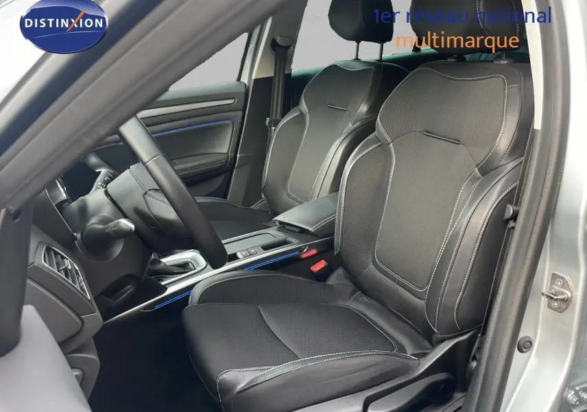 Intérieur de la Renault Mégane Break 2024 en gris Highland Metal, vue côté conducteur sur les sièges en cuir noir et console centrale.