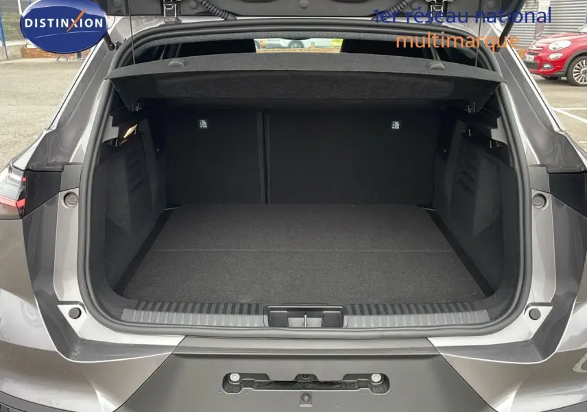 Coffre ouvert vu de l'arrière d'une Renault SYMBIOZ gris cassiopée métal, montrant un espace de chargement spacieux et propre.