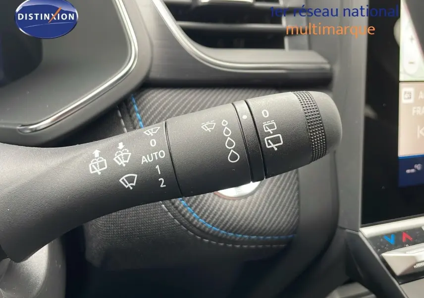 Gros plan sur la commande d'essuie-glace du Renault Symbioz gris Cassiopée, avec détails des réglages visibles sur fond carbone.