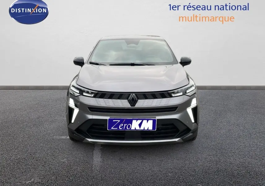 Vue frontale d'une Renault SYMBIOZ gris cassiopée métal avec éclairage LED et calandre moderne sur parking.