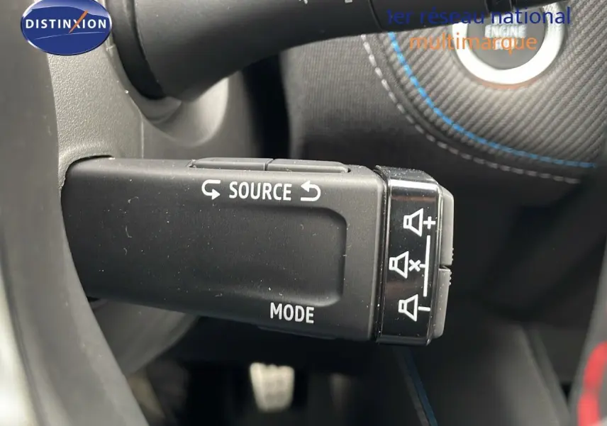 Gros plan sur la commande au volant du mode source dans l'habitacle noir du Renault Symbioz gris cassiopée métal 2025.