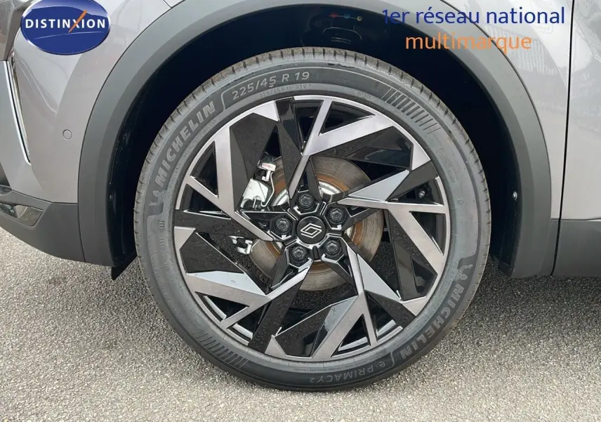 Gros plan sur la roue avant gauche du Renault Symbioz gris Cassiopée Métal avec jante noire et argentée au design géométrique.