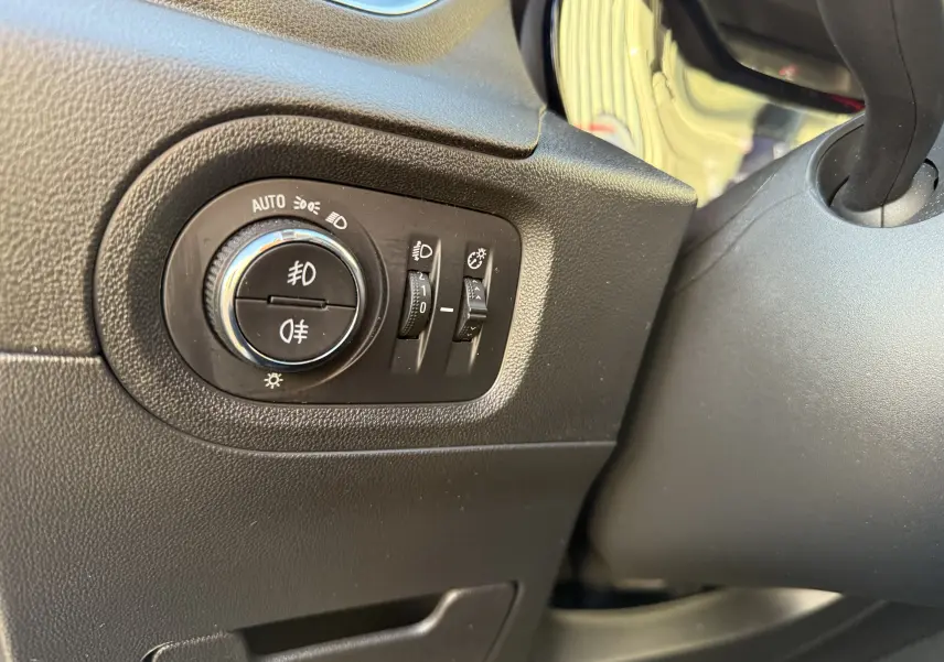 Gros plan sur les commandes d'éclairage à gauche du volant dans l'habitacle noir de l'Opel Grandland X gris quartz 2019.
