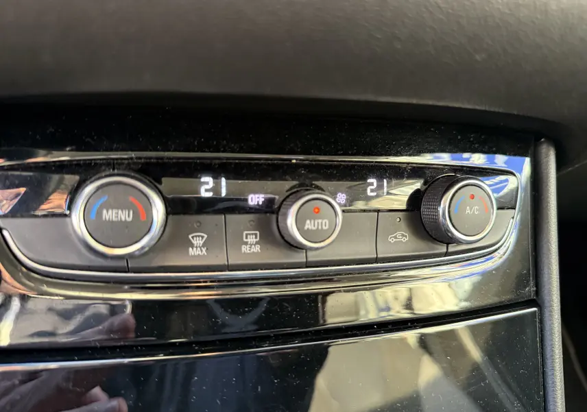 Gros plan sur la commande de climatisation automatique du tableau de bord de l’Opel Grandland X gris quartz.