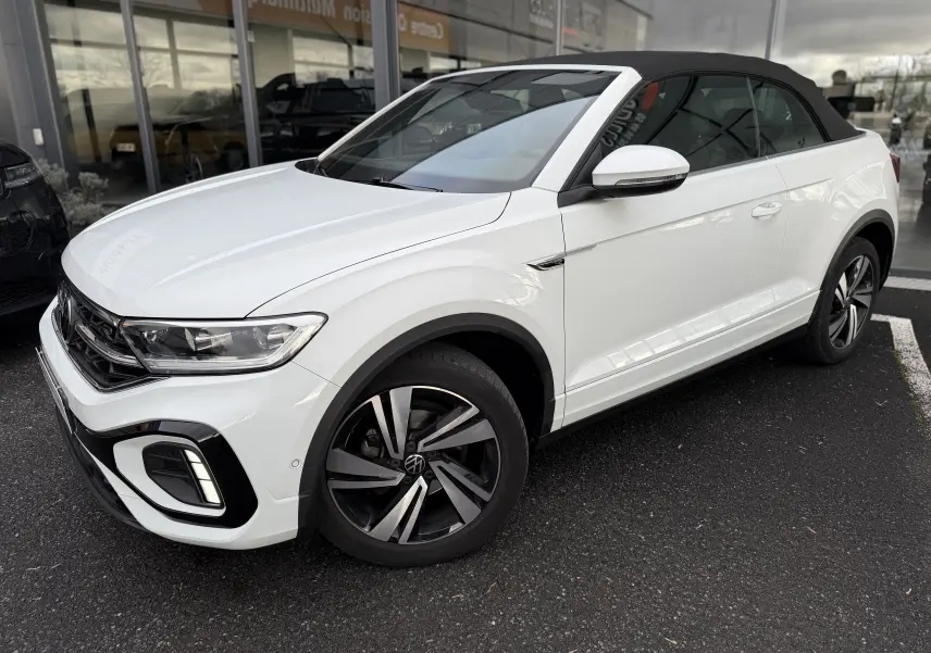 Volkswagen T-Roc Cabriolet blanc vue 3/4 avant droit avec toit noir et jantes R-Line distinctives.