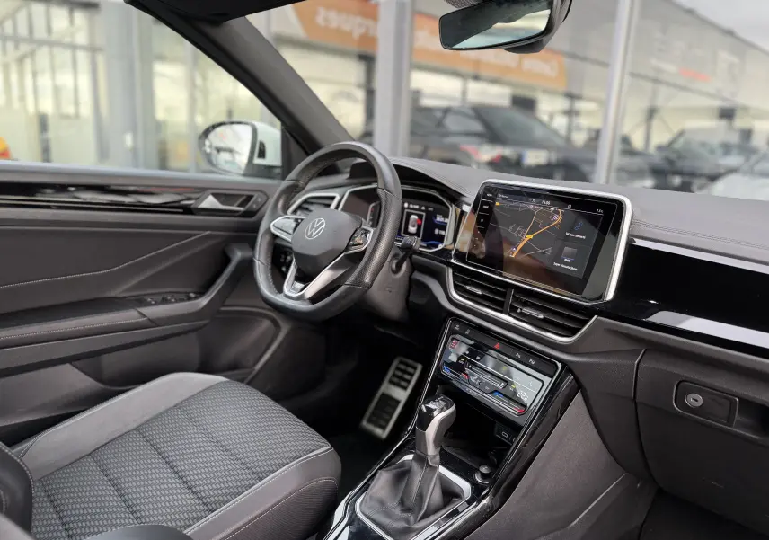 Vue intérieure côté conducteur du Volkswagen T-Roc Cabriolet blanc 2022, avec tableau de bord numérique et écran tactile central.