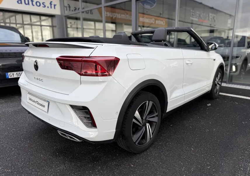 Volkswagen T-Roc Cabriolet blanc vue 3/4 arrière droit, capote ouverte, jantes R-Line distinctives.