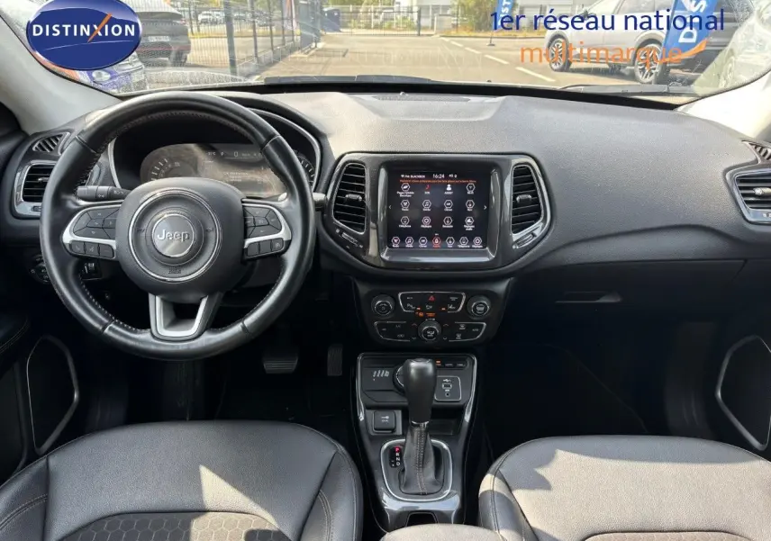 Vue intérieure du tableau de bord et volant du Jeep Compass 2021, avec écran tactile et sellerie cuir noire.