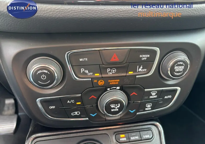 Gros plan sur la console centrale noire du Jeep Compass 2021, montrant les commandes de climatisation et multimédia.