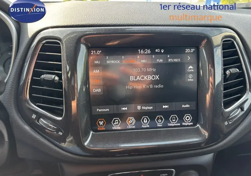 Écran tactile central du tableau de bord du Jeep Compass blanc, affichant la radio FM sur station BLACKBOX.