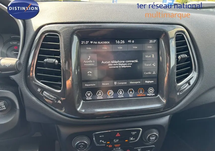 Vue rapprochée de la console centrale du Jeep Compass 2021, écran tactile allumé avec interface multimédia visible.