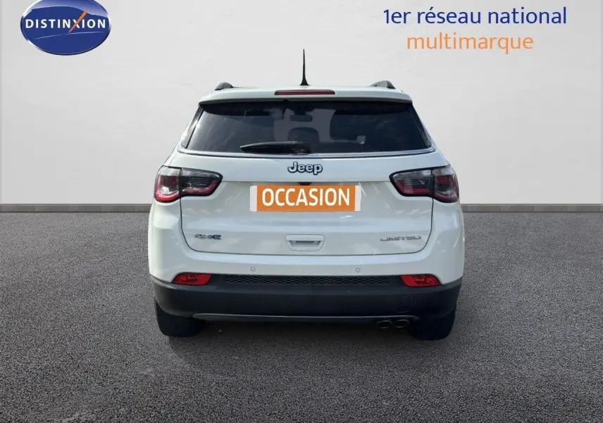Vue arrière d'un Jeep Compass blanc hybride rechargeable, version Limited, avec feux arrière LED et double sortie d'échappement.