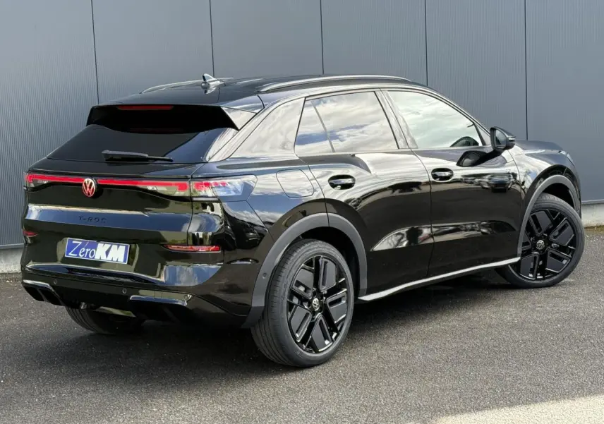 Volkswagen T-Roc noir ébène en 3/4 arrière droit, avec jantes noires 19 pouces et hayon électrique.