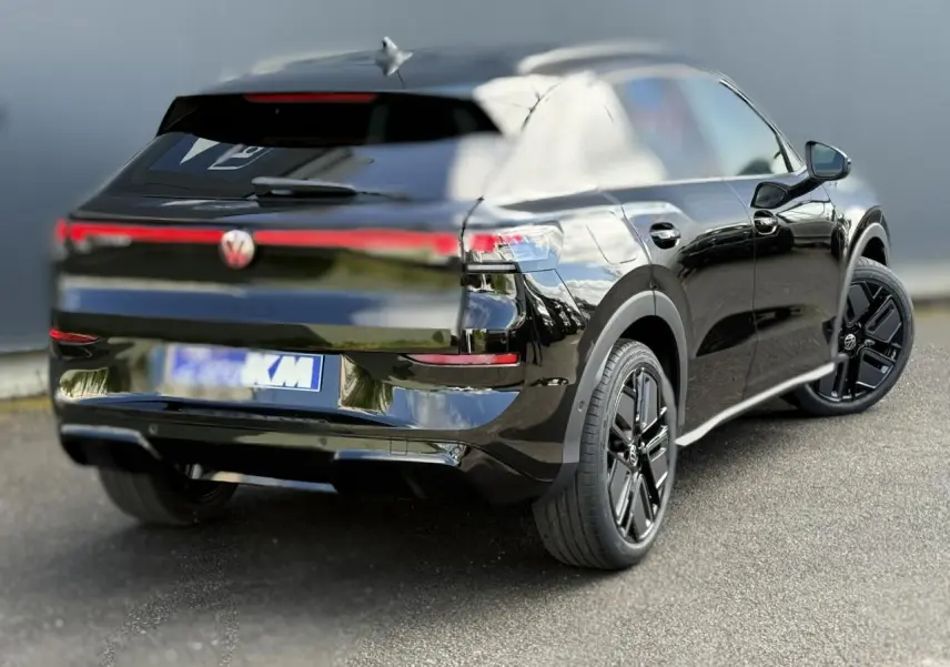 Volkswagen T-Roc noir ébène vu 3/4 arrière droit, avec jantes noires sport et feux arrière LED connectés.
