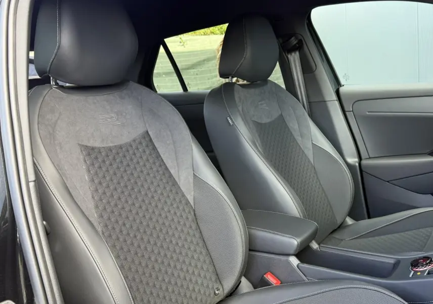 Vue intérieure des sièges avant en tissu gris et cuir noir du Volkswagen T-Roc 2026 version R-Line.