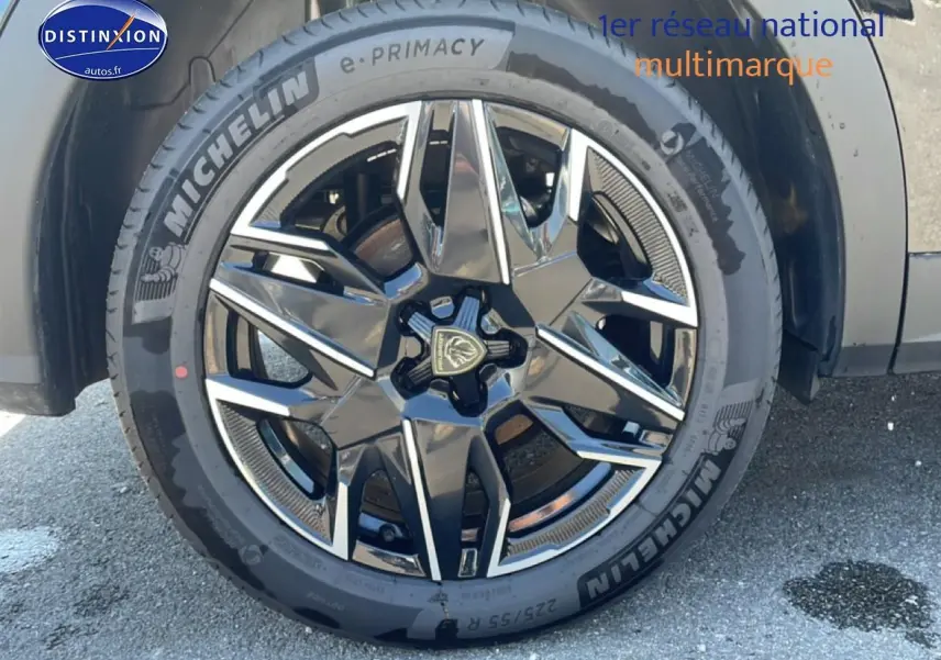 Gros plan sur la jante alu noire et argentée du côté droit d'un Peugeot 3008 noir, pneu Michelin visible.