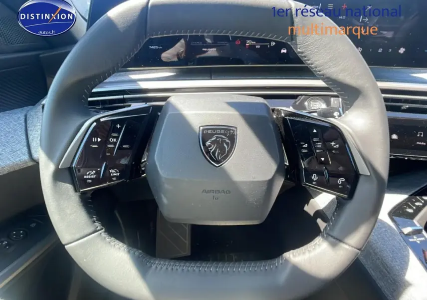Vue rapprochée du volant cuir gris du Peugeot 3008 1.2 hybrid 145 allure e-dcs6 avec commandes multifonctions.