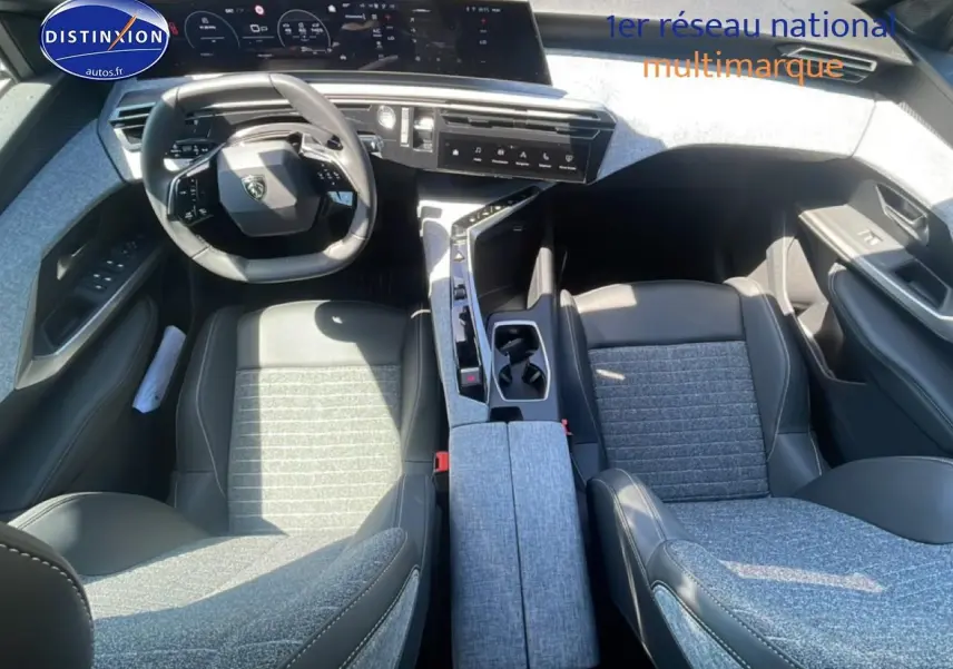 Vue intérieure de face du Peugeot 3008 2025, sièges bi-matière gris et noir avec tableau de bord digital et volant cuir.