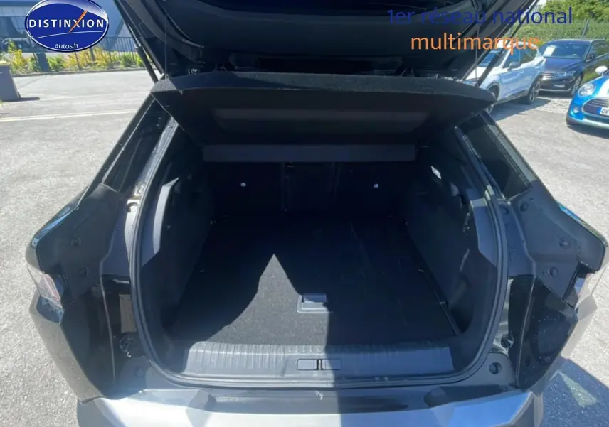 Coffre ouvert vu de l'arrière d'un Peugeot 3008 noir 2025, avec hayon relevé et espace de chargement vide.