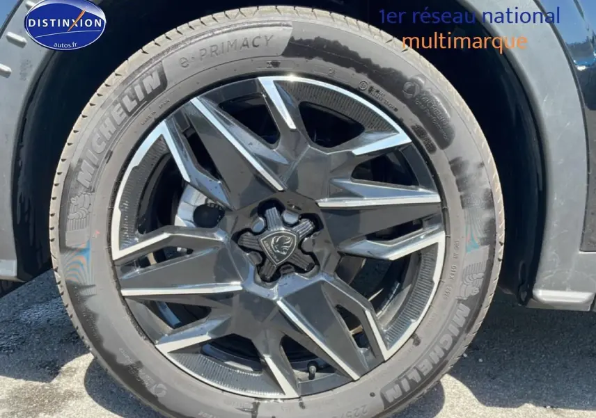 Gros plan sur la roue avant gauche noire du Peugeot 3008 1.2 hybrid 145 allure e-dcs6 avec jante alu distinctive.